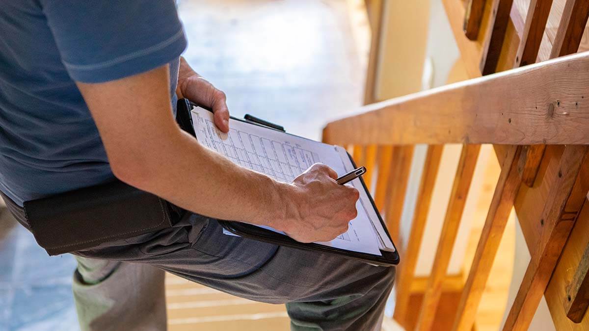 home inspector taking notes on staircase