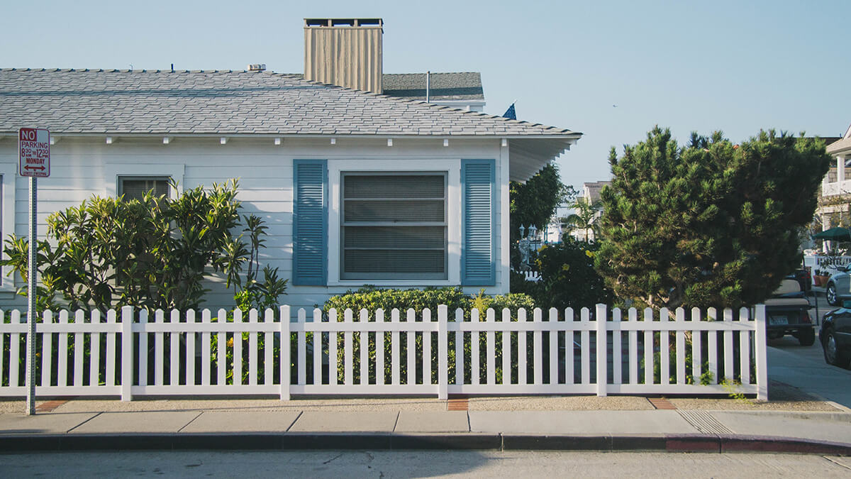 california home with white fence and blue window
