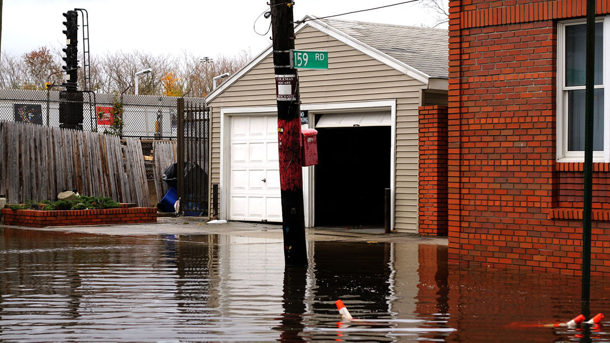 flooded garage with brick house on the right
