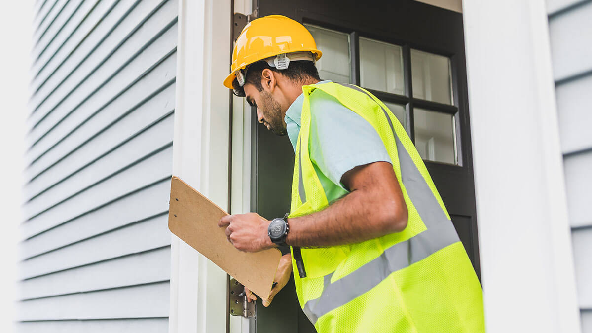 home inspector looking at condition of the home siding