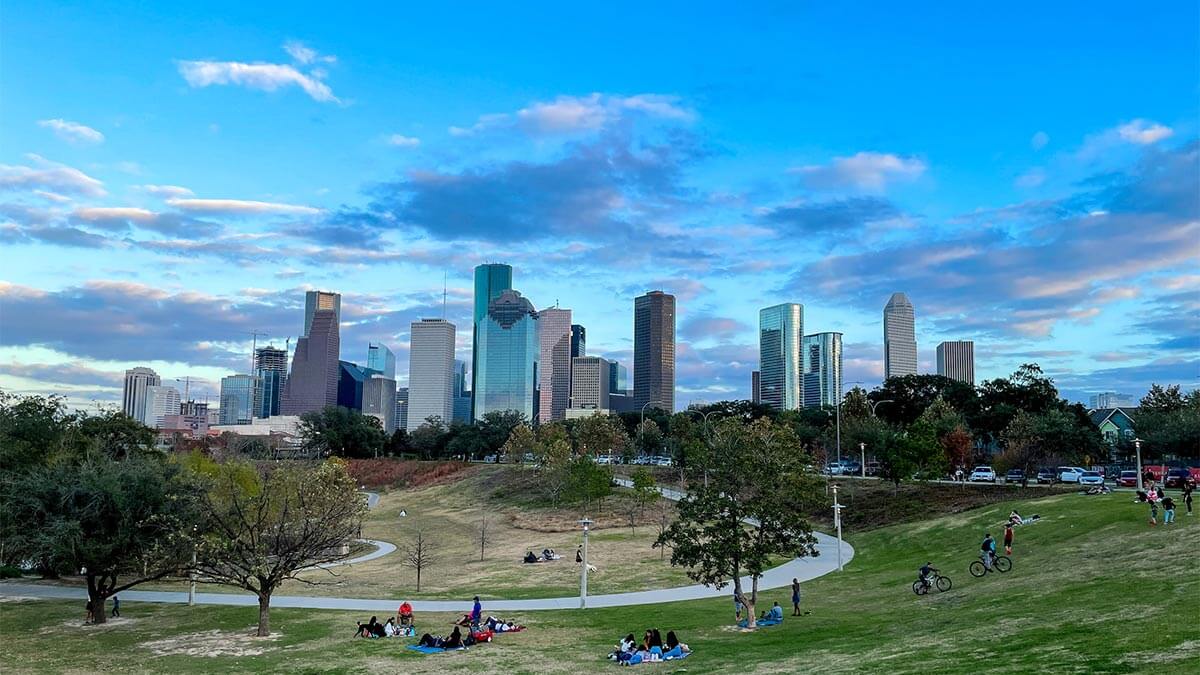 People in park with city skyline in Texas